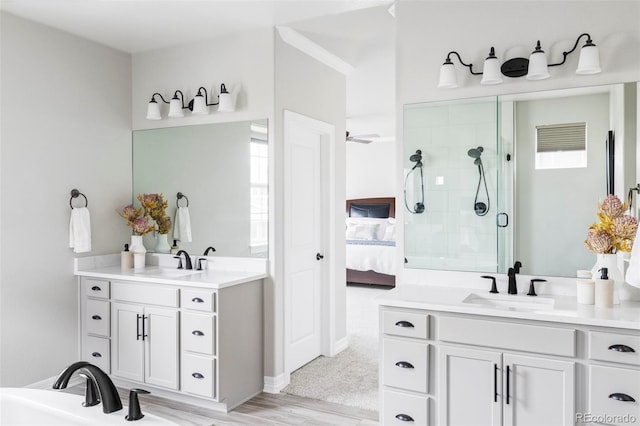 bathroom featuring a sink, a stall shower, ensuite bath, and two vanities