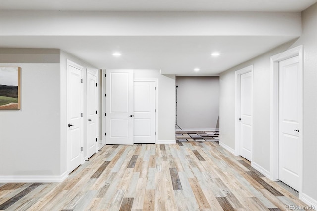 finished basement with light wood-style floors, recessed lighting, and baseboards