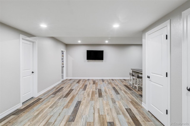 finished below grade area featuring recessed lighting, light wood-style floors, and baseboards