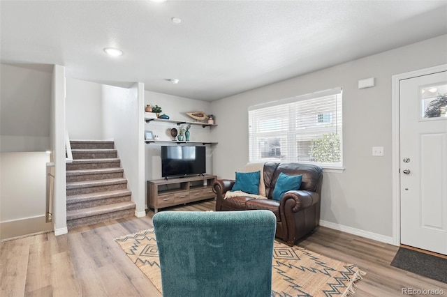 living room featuring recessed lighting, stairs, light wood finished floors, and baseboards