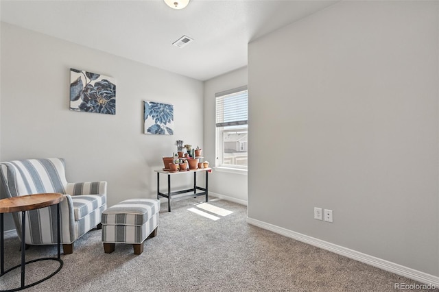 sitting room with carpet flooring, baseboards, and visible vents