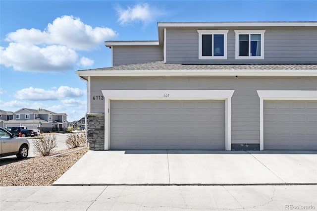view of property exterior featuring a residential view, roof with shingles, driveway, stone siding, and an attached garage