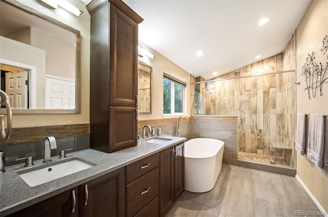 6480 Moss Cir, Arvada, CO 80007 - bathroom with a soaking tub, a shower stall, vaulted ceiling, double vanity, and tile walls