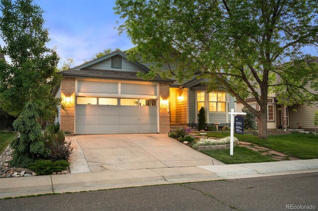 6480 Moss Cir, Arvada, CO 80007 - view of front of property with brick siding, concrete driveway, a garage, and a front yard