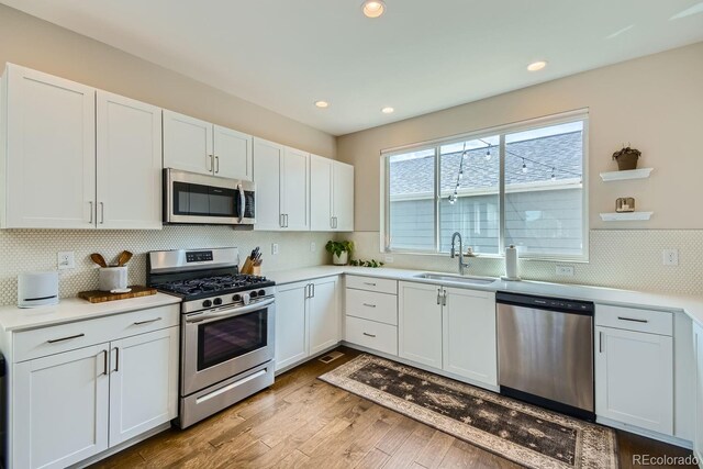 kitchen featuring stainless steel appliances, sink, and white cabinets