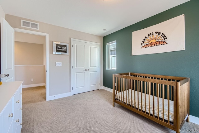 bedroom featuring a closet, carpet flooring, visible vents, and baseboards