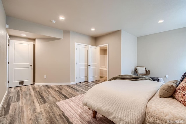 bedroom with recessed lighting, baseboards, ensuite bath, and light wood finished floors