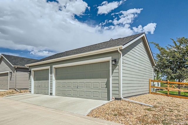 detached garage featuring fence