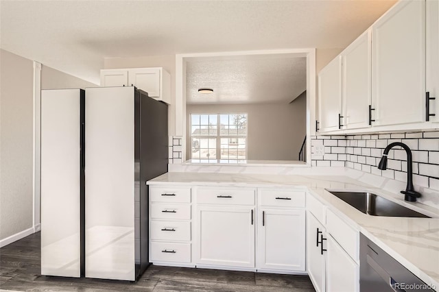 kitchen with stainless steel appliances, white cabinetry, and a sink