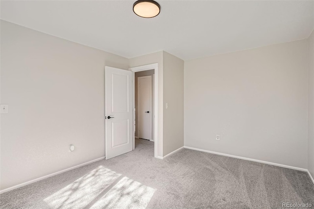 unfurnished bedroom featuring light carpet and baseboards