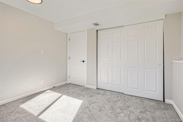 unfurnished bedroom featuring a closet, carpet flooring, visible vents, and baseboards