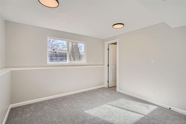 carpeted empty room featuring baseboards and a textured ceiling