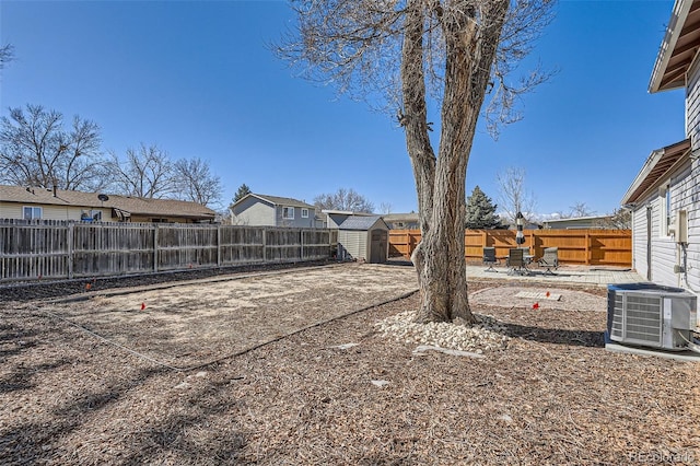 view of yard featuring a fenced backyard, central AC, an outdoor structure, a shed, and a patio area