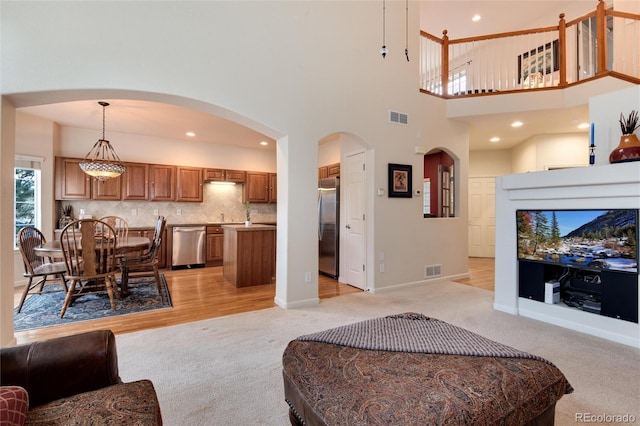 carpeted living room with a towering ceiling