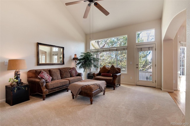 living room with ceiling fan, high vaulted ceiling, and light colored carpet