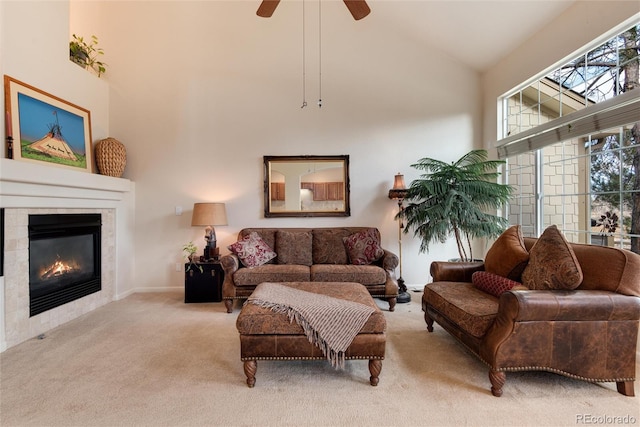 living room with ceiling fan, light colored carpet, a fireplace, and high vaulted ceiling