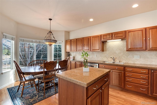 kitchen featuring sink, tasteful backsplash, stainless steel dishwasher, pendant lighting, and a kitchen island