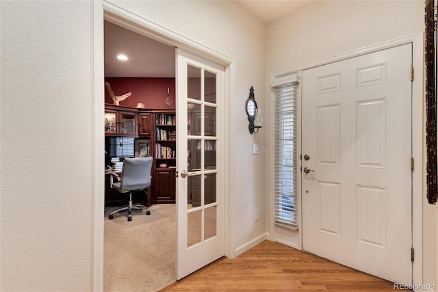 foyer with light hardwood / wood-style flooring and french doors