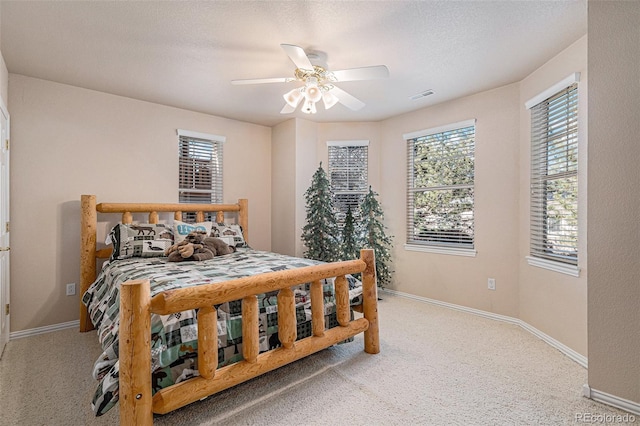 bedroom with multiple windows, ceiling fan, visible vents, and baseboards