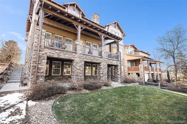 exterior space with board and batten siding, stone siding, a lawn, and a chimney