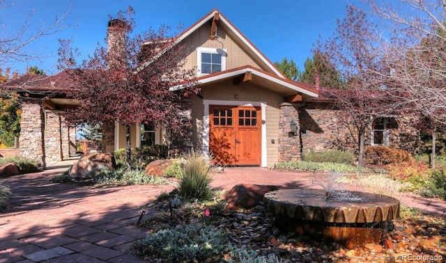 view of front of property with stone siding and a chimney