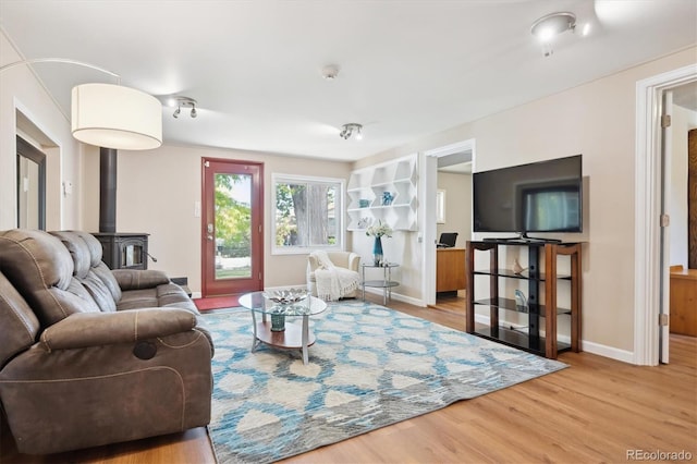 living room featuring a wood stove and light hardwood / wood-style flooring