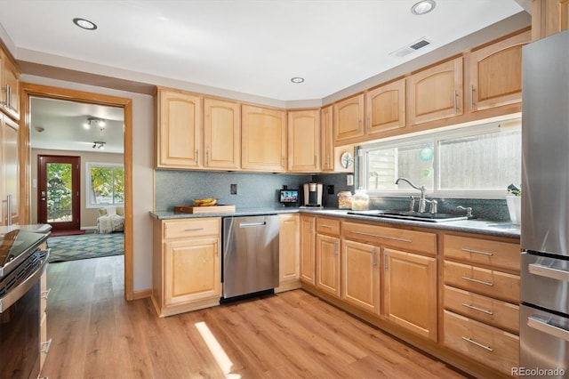 kitchen featuring sink, light brown cabinetry, light hardwood / wood-style floors, and appliances with stainless steel finishes