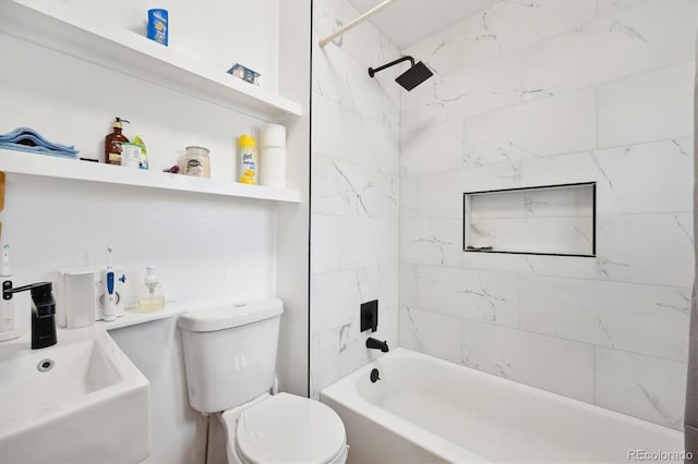 full bathroom featuring sink, tiled shower / bath combo, and toilet