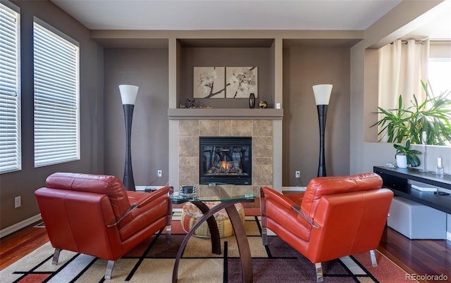 living room with hardwood / wood-style floors and a tiled fireplace