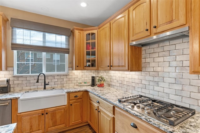 kitchen featuring stainless steel appliances, light stone countertops, and backsplash