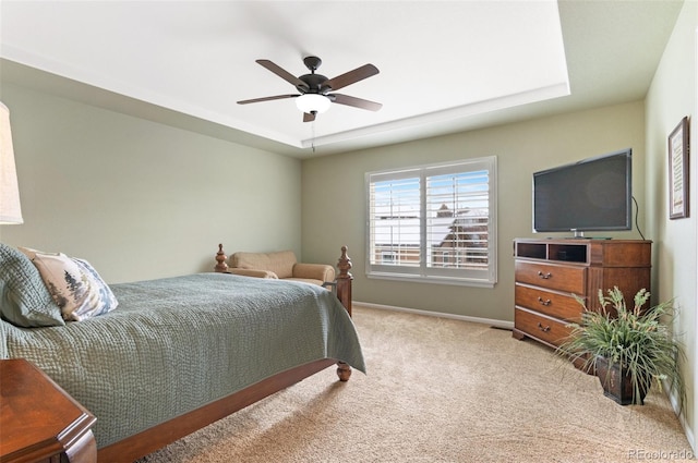 bedroom with ceiling fan, carpet flooring, and a raised ceiling