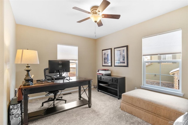 carpeted home office featuring ceiling fan