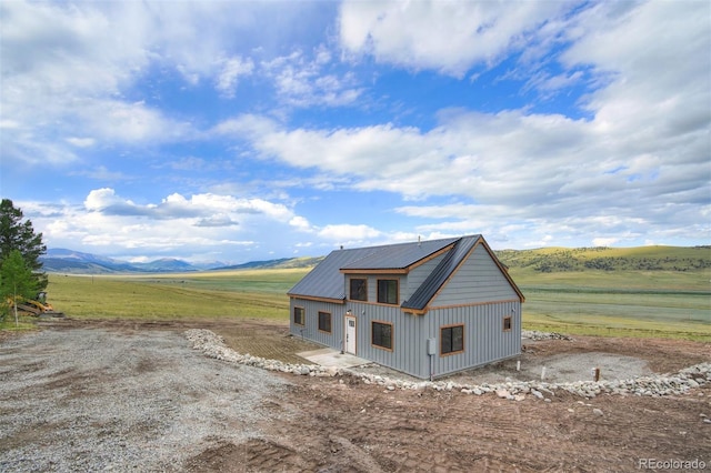 view of front of property featuring a mountain view, metal roof, and a rural view