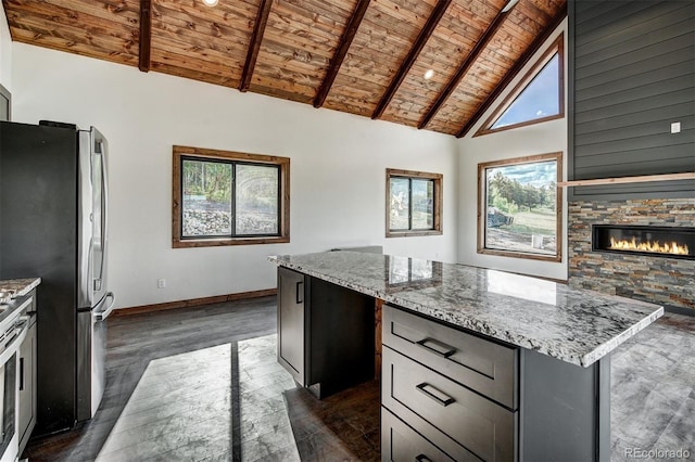 kitchen featuring wood ceiling, light stone counters, dark wood-type flooring, a center island, and high vaulted ceiling