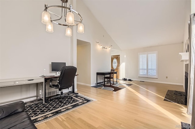 office featuring wood-type flooring, a chandelier, and high vaulted ceiling