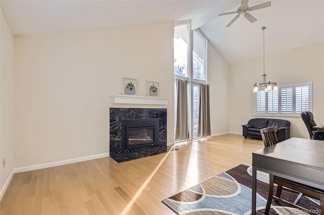 living room featuring a high end fireplace, a wealth of natural light, and wood-type flooring