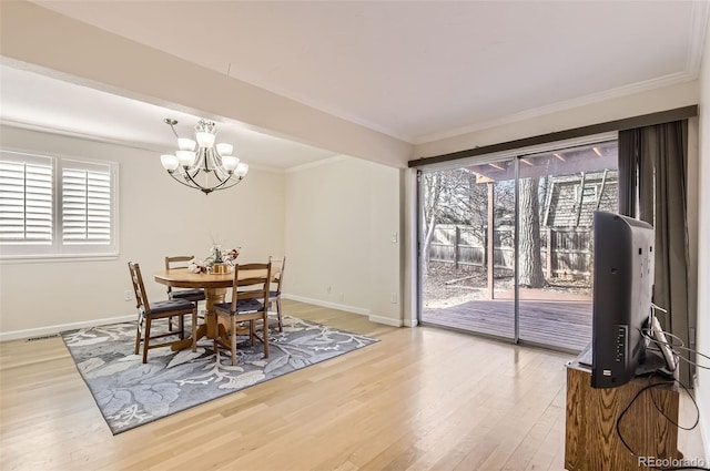 dining area with crown molding, plenty of natural light, a chandelier, and wood-type flooring