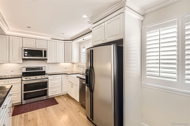 kitchen featuring sink, crown molding, white cabinets, and appliances with stainless steel finishes