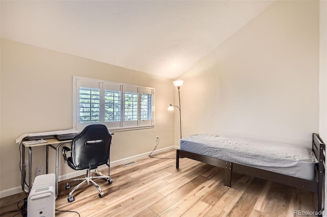 bedroom with lofted ceiling and light wood-type flooring