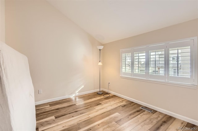 unfurnished room with lofted ceiling and light hardwood / wood-style floors