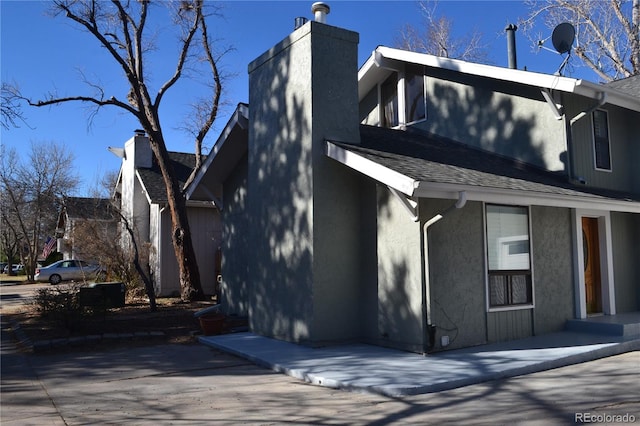 9551 E Chenango Ave, Greenwood Village, CO 80111 - exterior space with stucco siding, a chimney, and roof with shingles