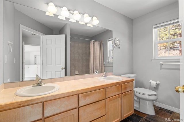 6904 Sprucedale Park Way, Evergreen, CO 80439 - bathroom featuring toilet, double vanity, a tile shower, and baseboards