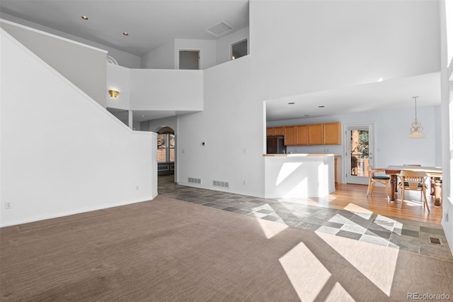 6904 Sprucedale Park Way, Evergreen, CO 80439 - unfurnished living room with arched walkways, light colored carpet, a towering ceiling, recessed lighting, and baseboards
