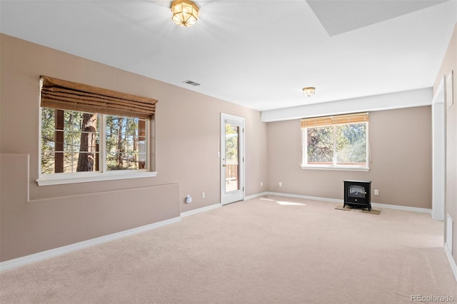 6904 Sprucedale Park Way, Evergreen, CO 80439 - unfurnished living room with a wood stove, light carpet, and baseboards