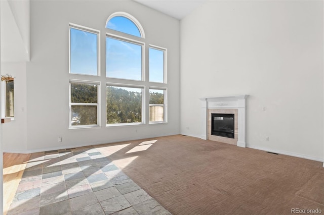 6904 Sprucedale Park Way, Evergreen, CO 80439 - unfurnished living room with a high ceiling, a fireplace, baseboards, and carpet flooring
