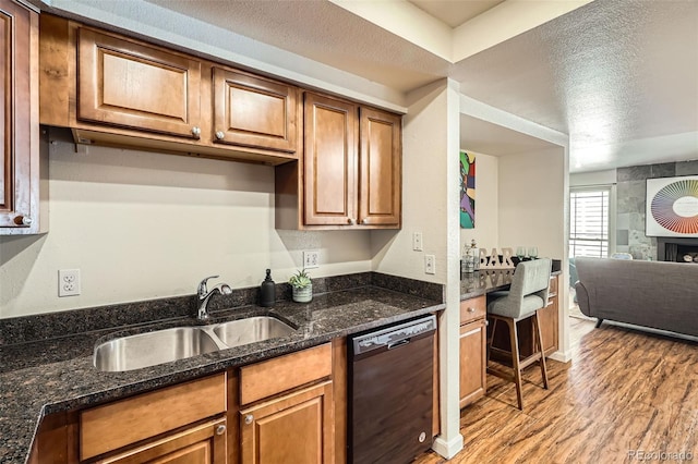 701 Harlan St Unit E59, Lakewood, CO 80214 - kitchen with a sink, light wood-style flooring, black dishwasher, and brown cabinets