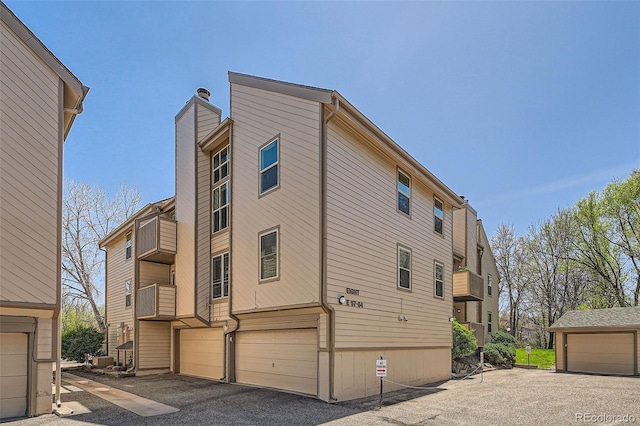 701 Harlan St Unit E59, Lakewood, CO 80214 - view of side of property featuring a garage and a chimney
