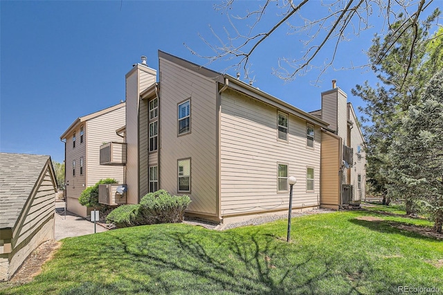 701 Harlan St Unit E59, Lakewood, CO 80214 - view of property exterior with a chimney and a yard