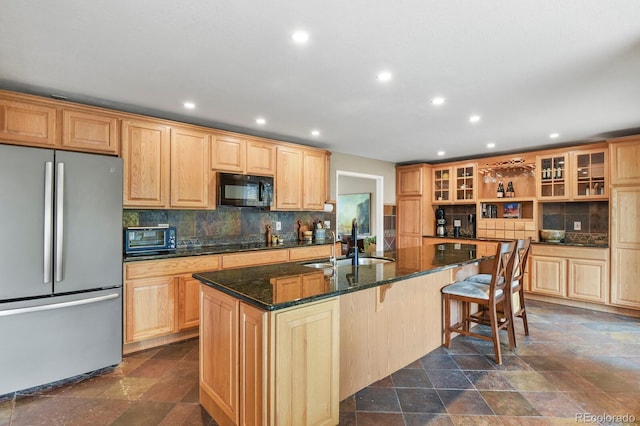 kitchen with freestanding refrigerator, black microwave, a sink, decorative backsplash, and recessed lighting
