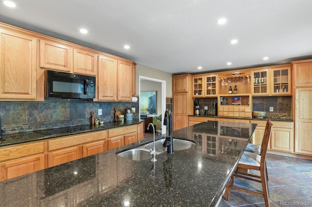 kitchen featuring black appliances, a sink, recessed lighting, backsplash, and glass insert cabinets